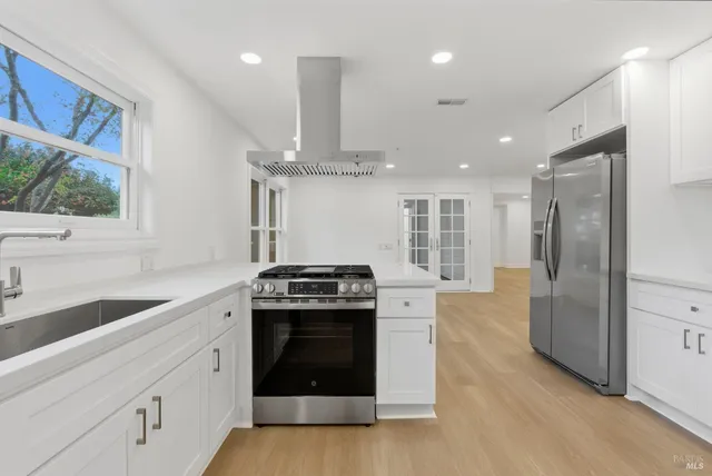a kitchen with stainless steel appliances granite countertop a stove a sink and a refrigerator