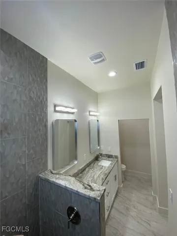 a bathroom with granite countertop a sink and a mirror