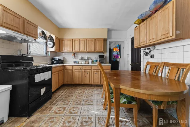 a kitchen with a dining table chairs and cabinets