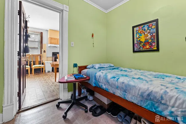 a bedroom with a bed a table and painting on the wall