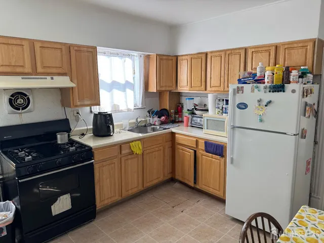 a kitchen with a refrigerator stove and sink
