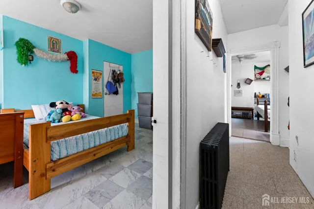 a view of kids bedroom with baby crib and toys