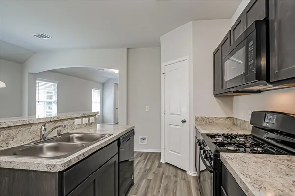 a kitchen with stainless steel appliances granite countertop a sink stove oven and refrigerator