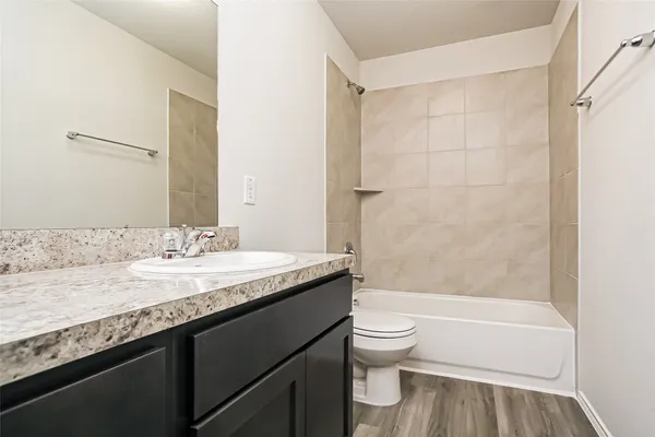 a bathroom with a granite countertop sink toilet and shower