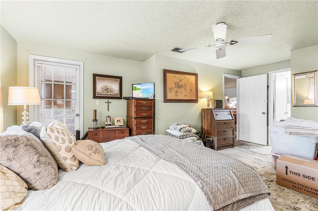 5579 Rattlesnake Hammock Road, Unit B9 Naples, FL 34113 - Photo 11 of 20 a bedroom with a bed and a chandelier