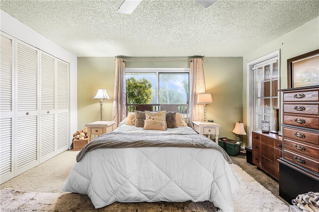 5579 Rattlesnake Hammock Road, Unit B9 Naples, FL 34113 - Photo 12 of 20 a bedroom with a bed and wooden floor