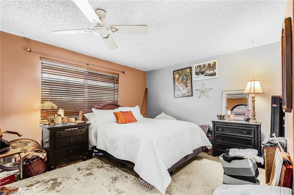 5579 Rattlesnake Hammock Road, Unit B9 Naples, FL 34113 - Photo 13 of 20 a bedroom with a bed dresser and a window