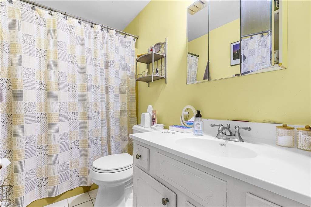 5579 Rattlesnake Hammock Road, Unit B9 Naples, FL 34113 - Photo 14 of 20 a bathroom with a sink a toilet and shower curtain