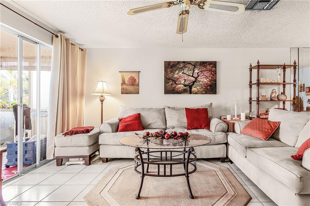 5579 Rattlesnake Hammock Road, Unit B9 Naples, FL 34113 - Photo 7 of 20 a living room with furniture and a floor to ceiling window