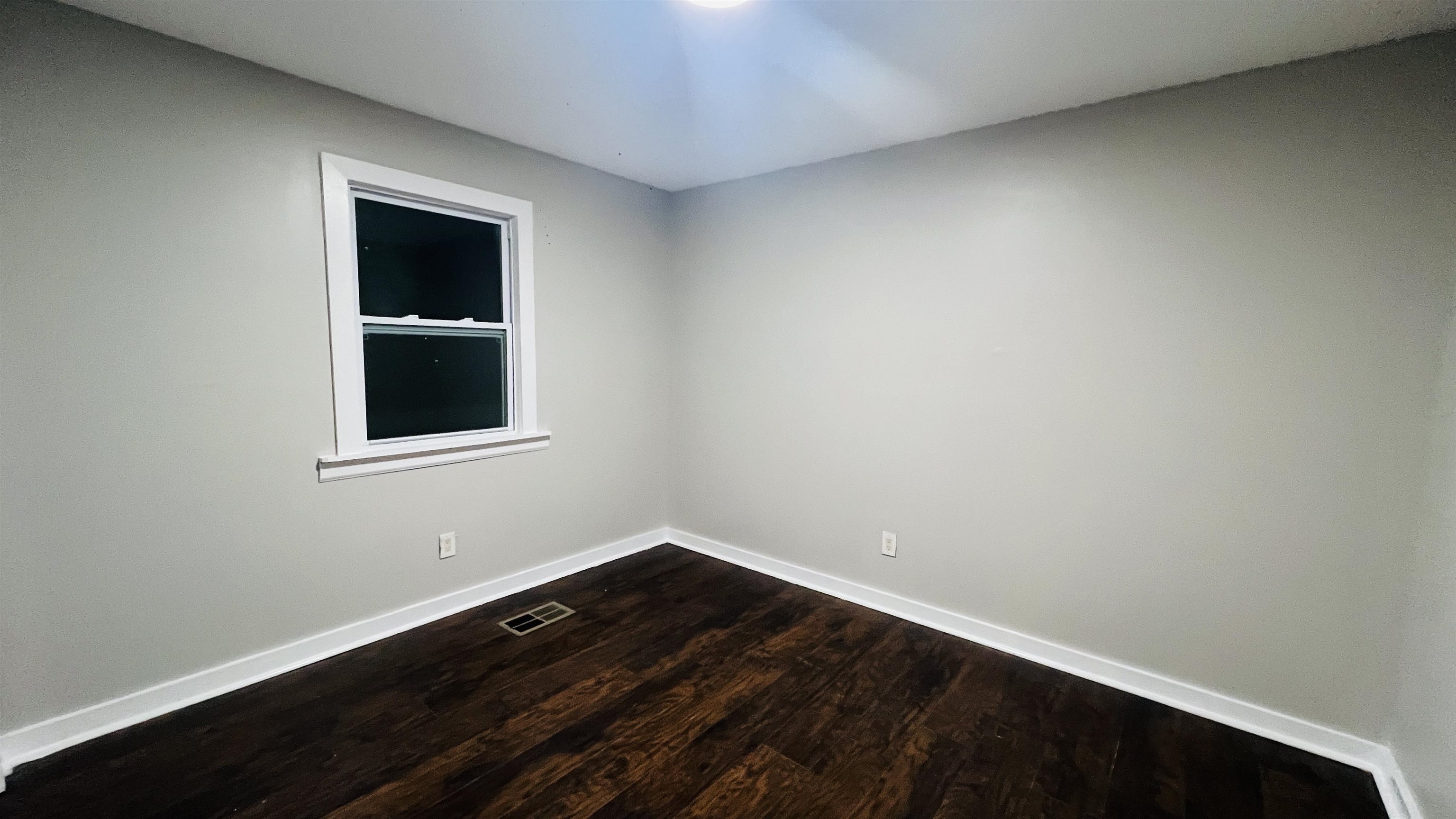 8645 Loomis Road Bartlett, TN 38002 - Photo 11 of 15 a view of an empty room with wooden floor and a window