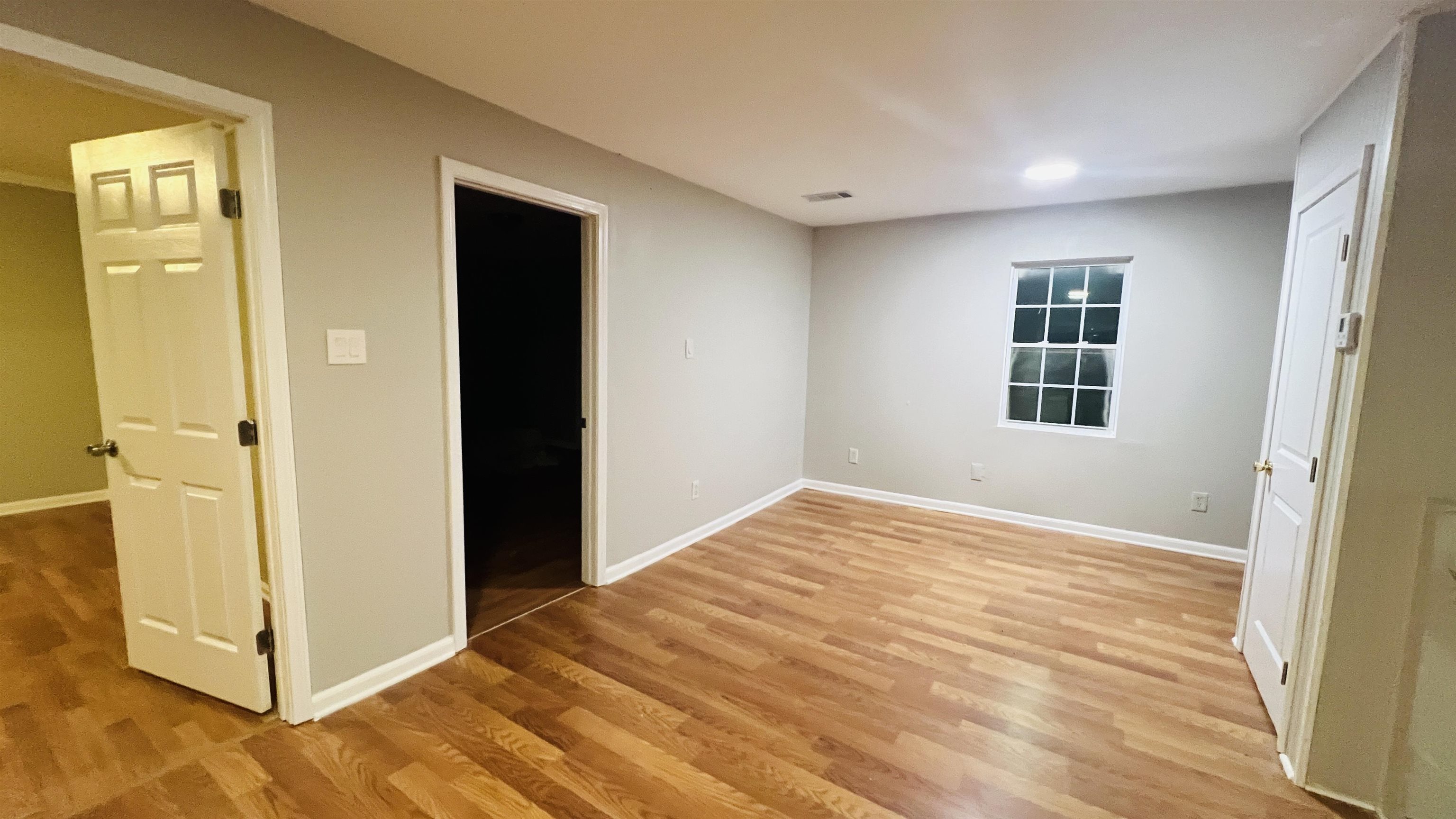 8645 Loomis Road Bartlett, TN 38002 - Photo 8 of 15 a view of an empty room with wooden floor and a window