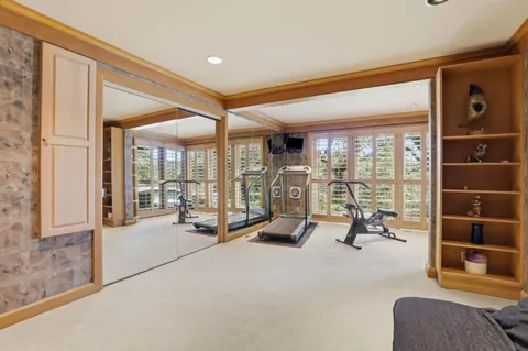a view of a room with gym equipment and floor to ceiling window