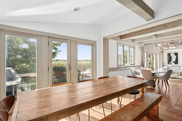 a view of a dining room with furniture large windows and wooden floor