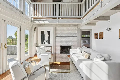 a living room with furniture a fireplace and a large window