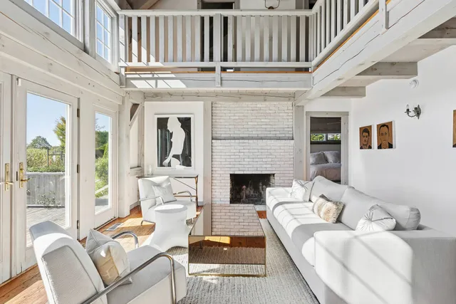 a living room with furniture a fireplace and a large window