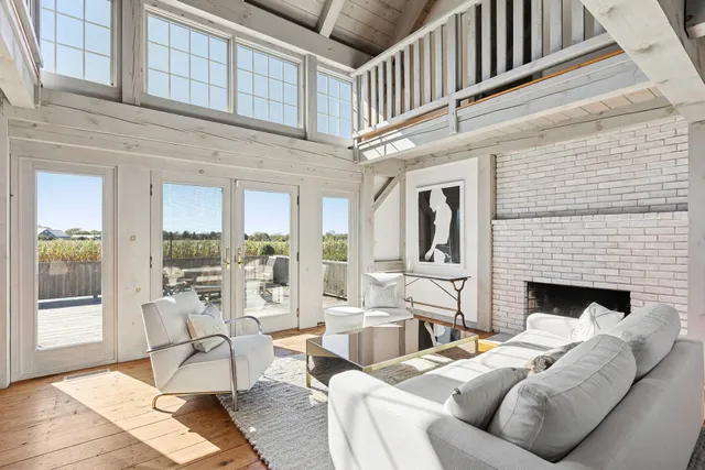 a living room with furniture a fireplace and a floor to ceiling window