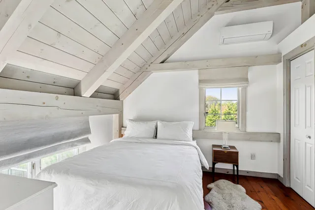 a bedroom with a bed chair and a window