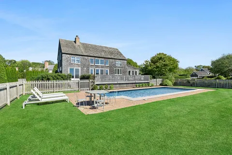 a view of a house with pool and a yard
