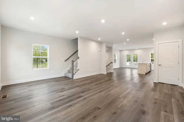 a view of empty room with wooden floor and windows