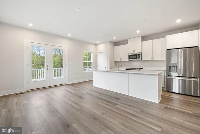 a kitchen with stainless steel appliances a refrigerator sink and microwave