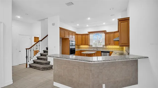 a kitchen with granite countertop cabinets stainless steel appliances and a counter space
