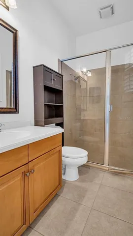 a view of an empty room with wooden floor and a ceiling fan