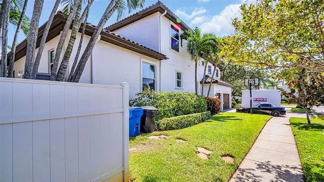 a front view of a house with a yard and potted plants