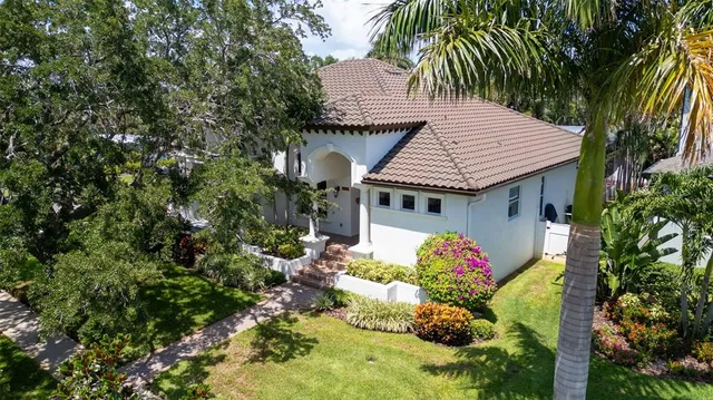 an aerial view of a house with a garden and lake view