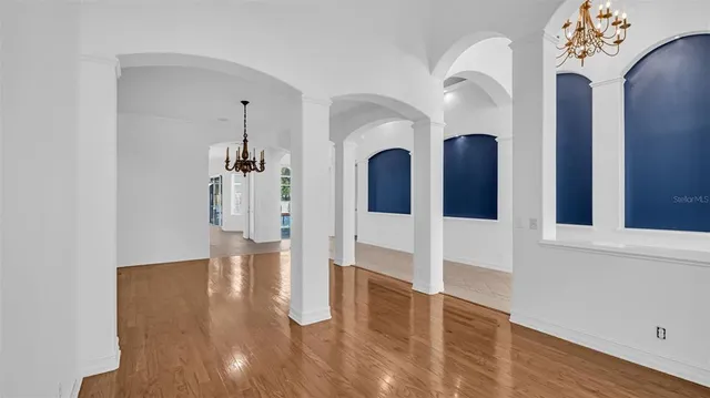 a view of a hallway with wooden floor and windows
