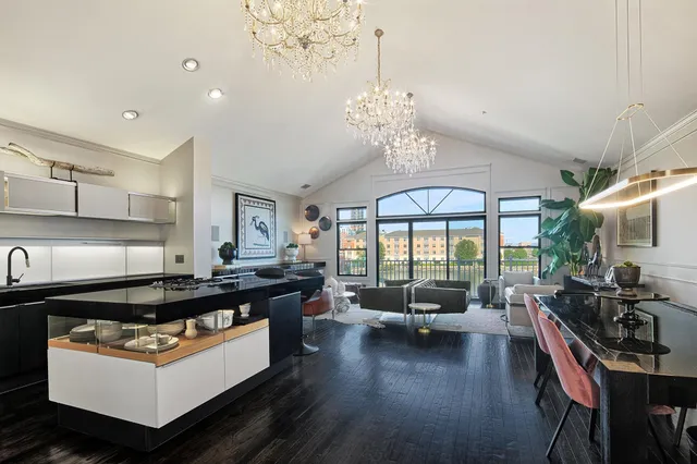 a kitchen with stainless steel appliances granite countertop a stove top oven a dining table and chairs with wooden floor