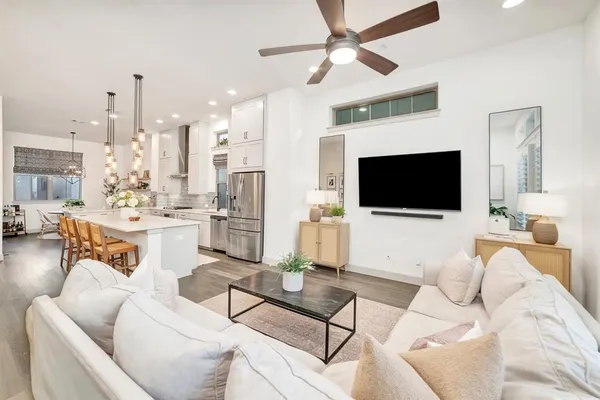 a living room with furniture a flat screen tv and kitchen view