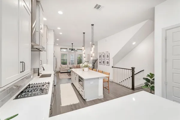 a kitchen with counter top space wooden floor and stainless steel appliances