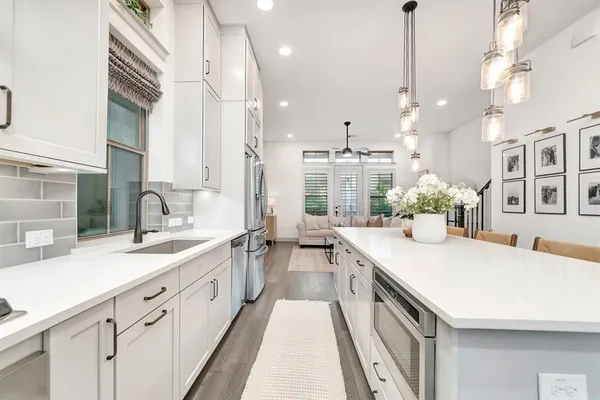 a kitchen with stainless steel appliances kitchen island granite countertop a table and chairs in it