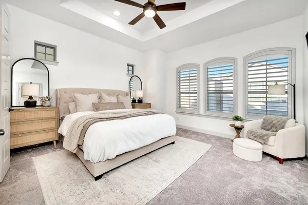 a spacious bedroom with a bed and a flat screen tv