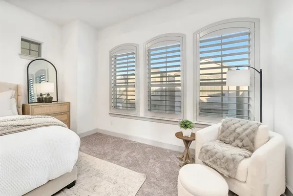 a spacious bedroom with a bed and a flat screen tv