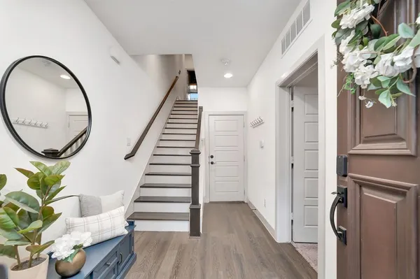 a view of a hallway with wooden floor and entryway