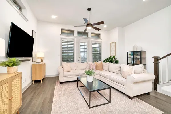 a living room with furniture a flat screen tv and a large window