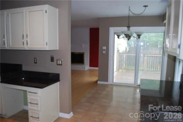 a kitchen with granite countertop a refrigerator a stove a road and a window