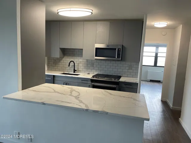 a kitchen with stainless steel appliances a sink a stove and microwave