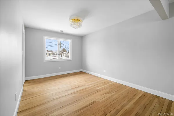 an empty room with a wooden floor and window