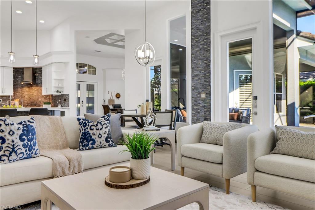 a living room with furniture potted plant and kitchen view