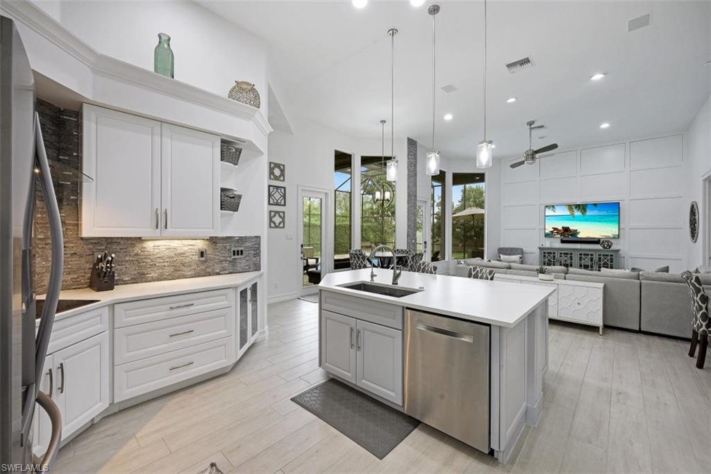 7235 Mill Run Road Naples, FL 34109 - Photo 14 of 31 a kitchen with kitchen island granite countertop a sink cabinets and wooden floor