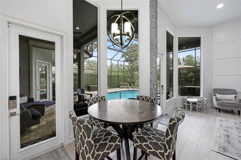 7235 Mill Run Road Naples, FL 34109 - Photo 15 of 31 a living room with furniture and a floor to ceiling window