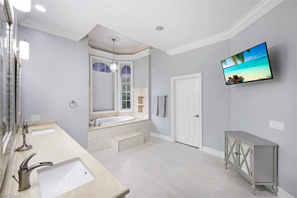 7235 Mill Run Road Naples, FL 34109 - Photo 20 of 31 a bathroom with a tub sink and mirror