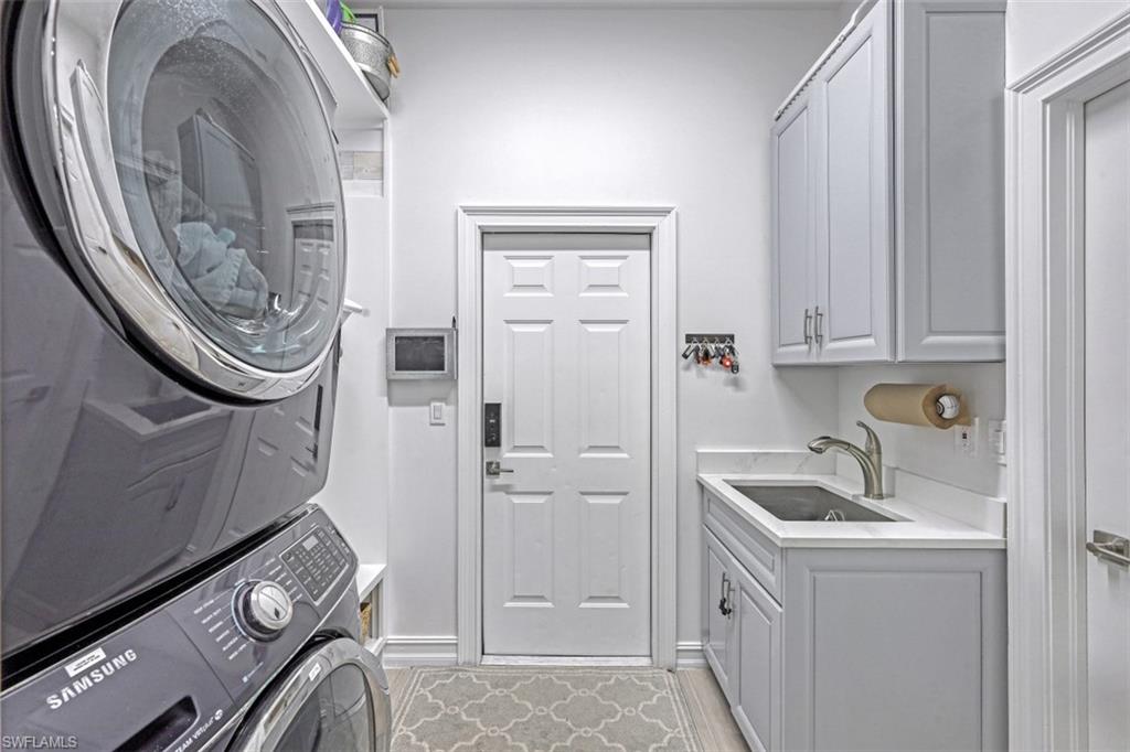 7235 Mill Run Road Naples, FL 34109 - Photo 26 of 31 a kitchen with white cabinets and a sink