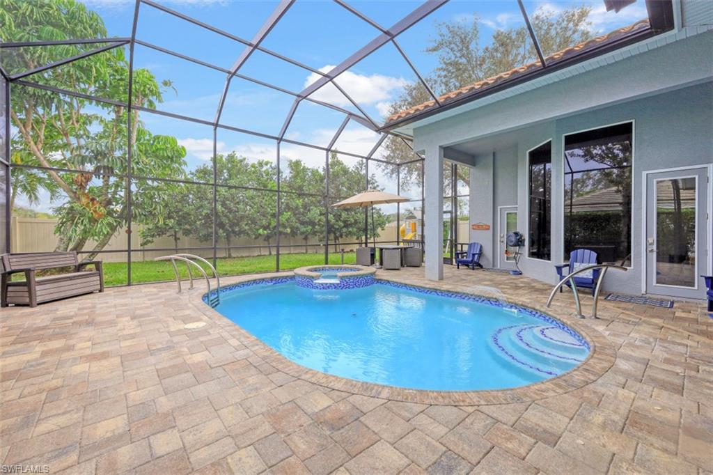 7235 Mill Run Road Naples, FL 34109 - Photo 30 of 31 a view of a swimming pool with a lounge chairs in patio
