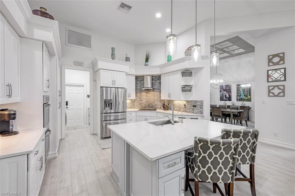 7235 Mill Run Road Naples, FL 34109 - Photo 3 of 31 a kitchen with stainless steel appliances kitchen island a refrigerator and a stove