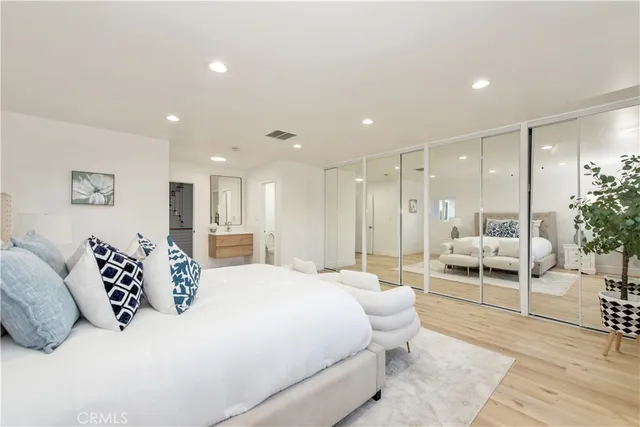 a bedroom with a large bed and a view of kitchen