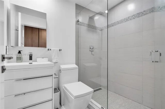 a bathroom with a sink toilet vanity and shower