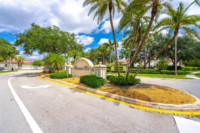 a view of a swimming pool with a garden and palm trees